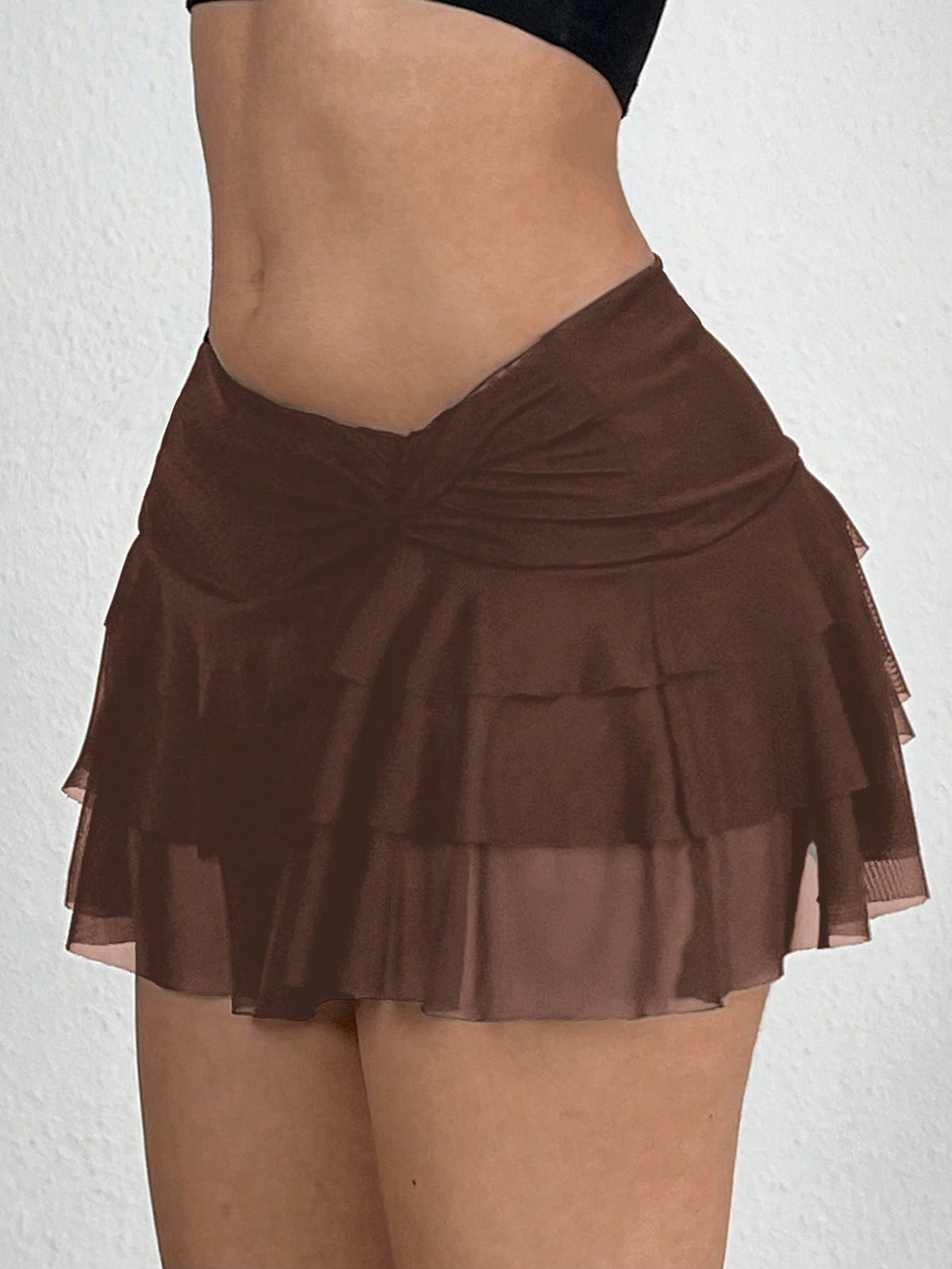 Black tiered ruffle mini cake skirt for women featuring a mid-waist pleated design and layered ruffle hem.
