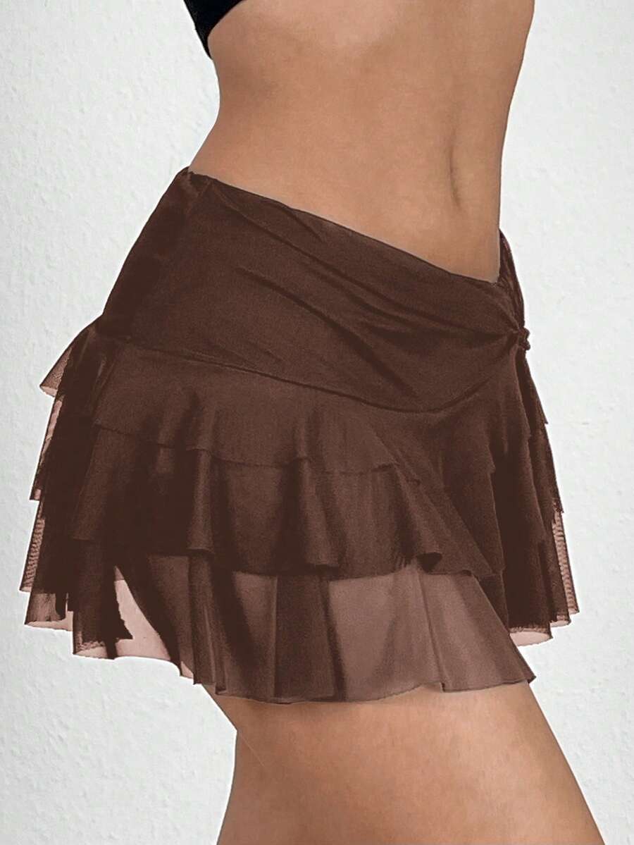 Black tiered ruffle mini cake skirt for women featuring a mid-waist pleated design and layered ruffle hem.