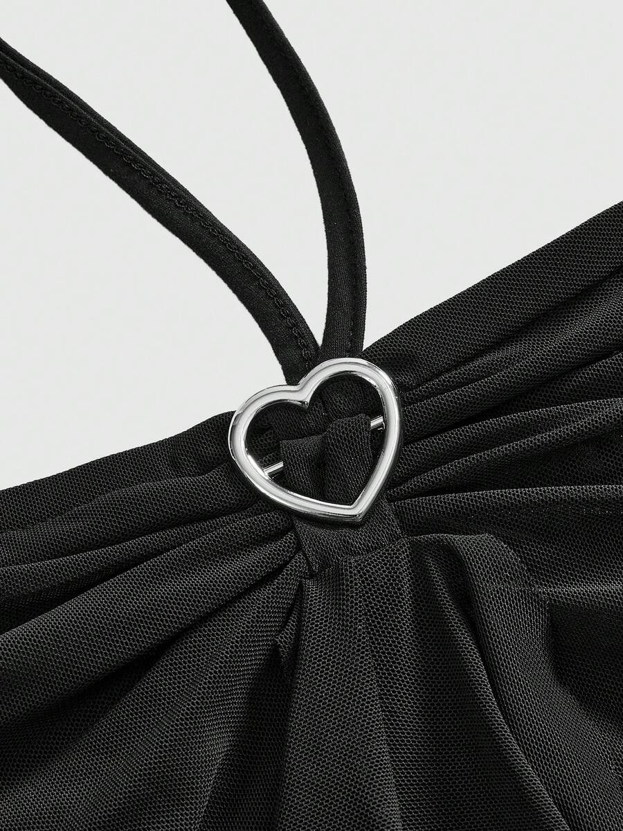 Women's black halter crop top featuring a backless cut, front ring detail, knot accent, asymmetrical hem, and high-stretch mesh fabric.
