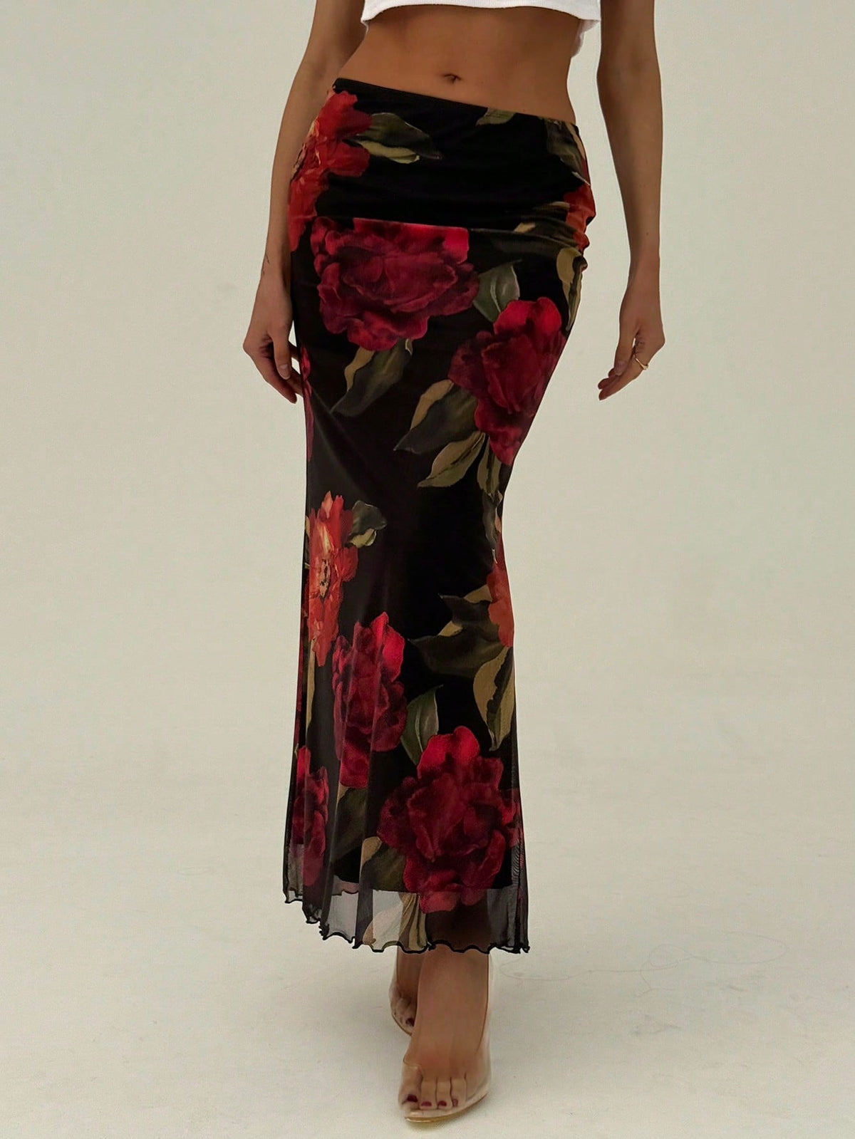 Black floral print mesh maxi skirt for women featuring high waist, ruched asymmetrical design, lettuce trim, and mermaid hem.