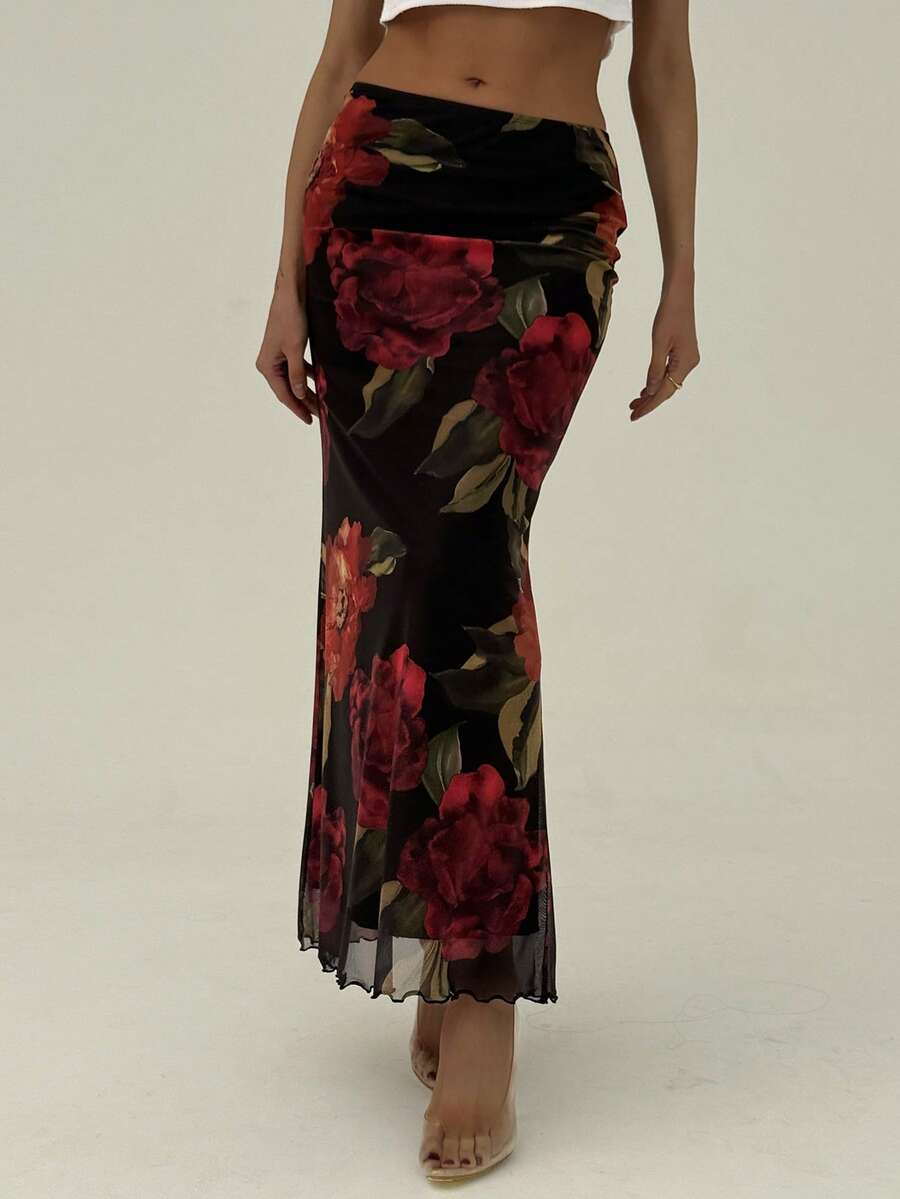 Black floral print mesh maxi skirt for women featuring high waist, ruched asymmetrical design, lettuce trim, and mermaid hem.