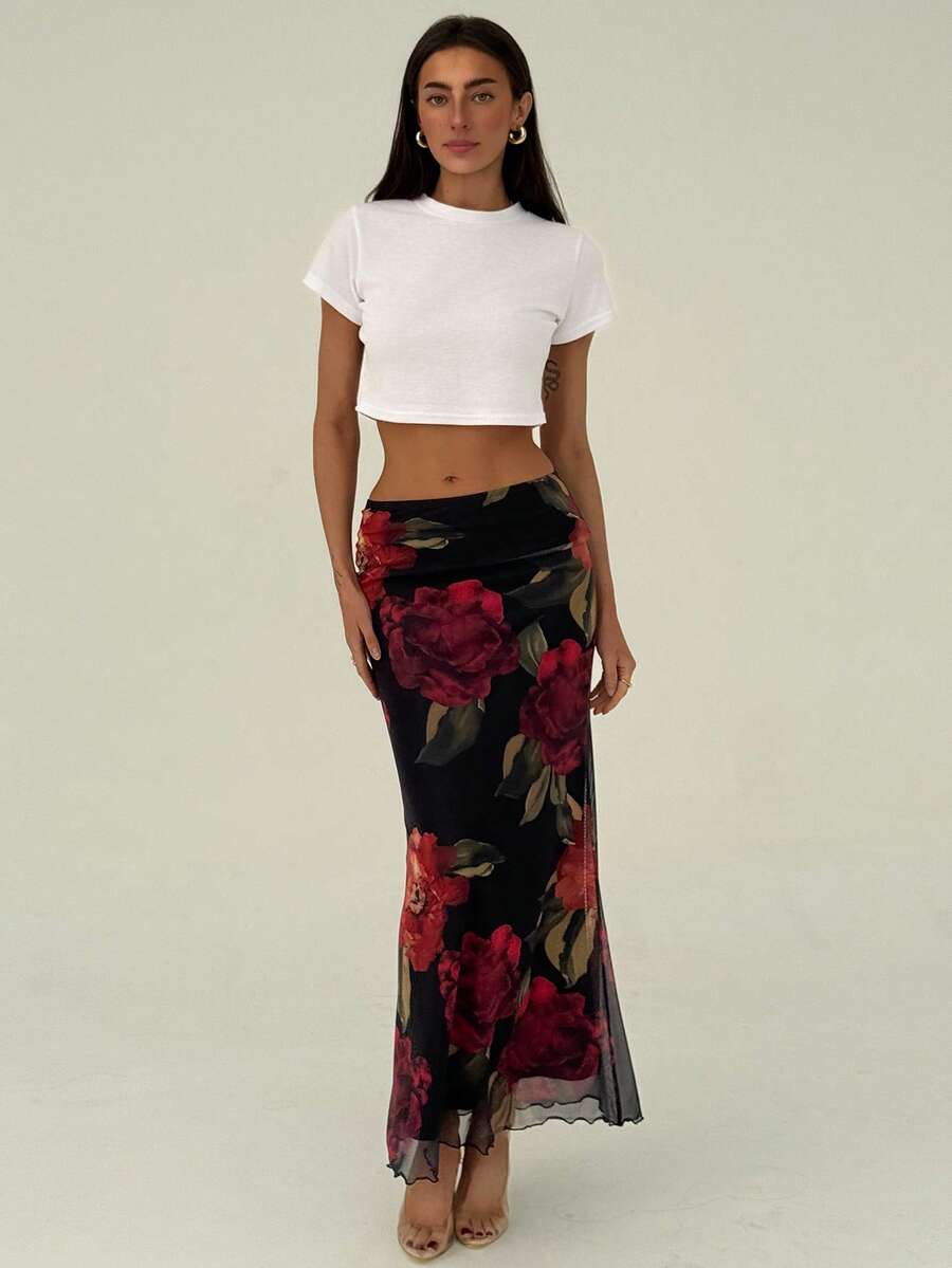 Black floral print mesh maxi skirt for women featuring high waist, ruched asymmetrical design, lettuce trim, and mermaid hem.