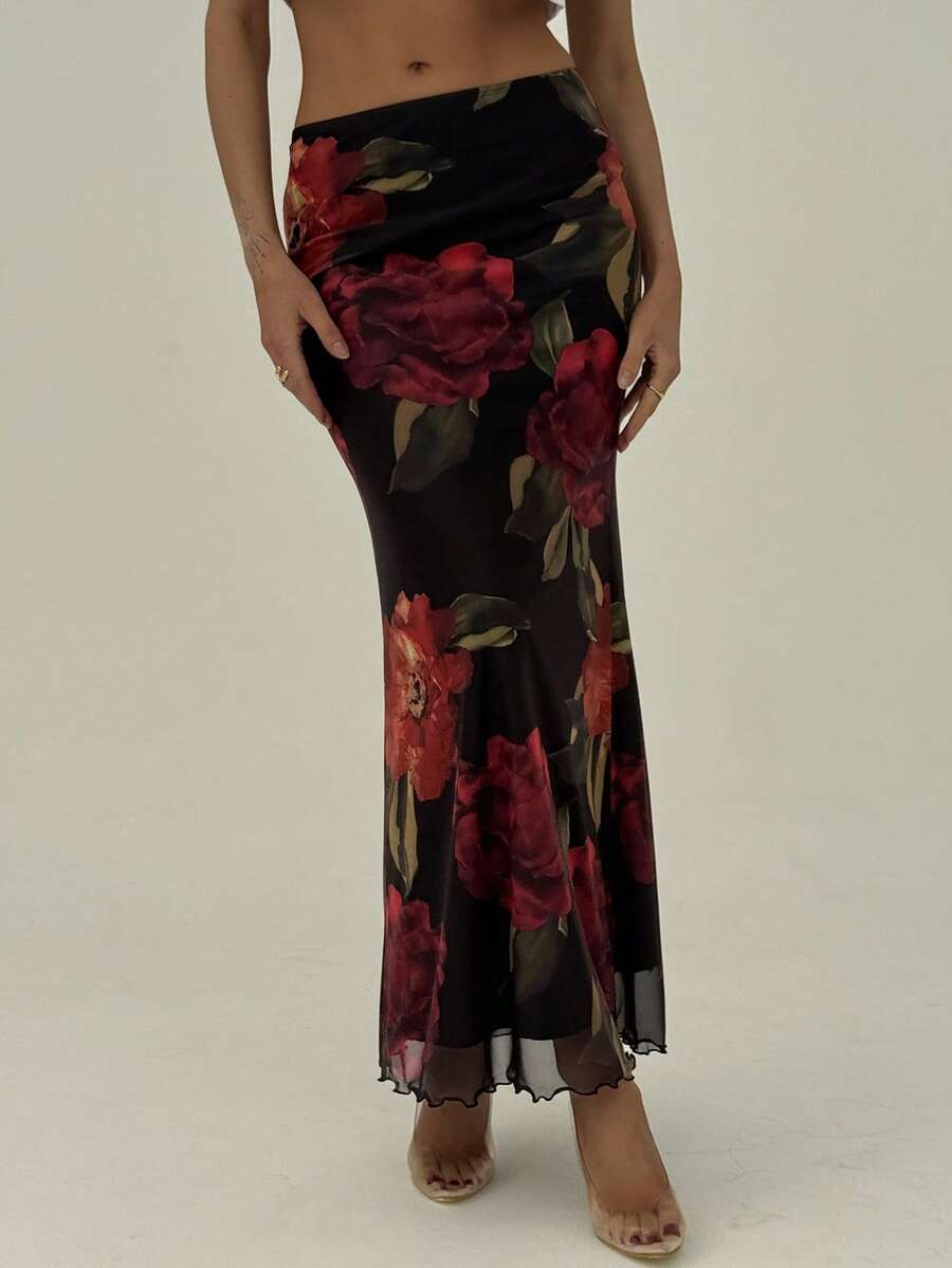 Black floral print mesh maxi skirt for women featuring high waist, ruched asymmetrical design, lettuce trim, and mermaid hem.