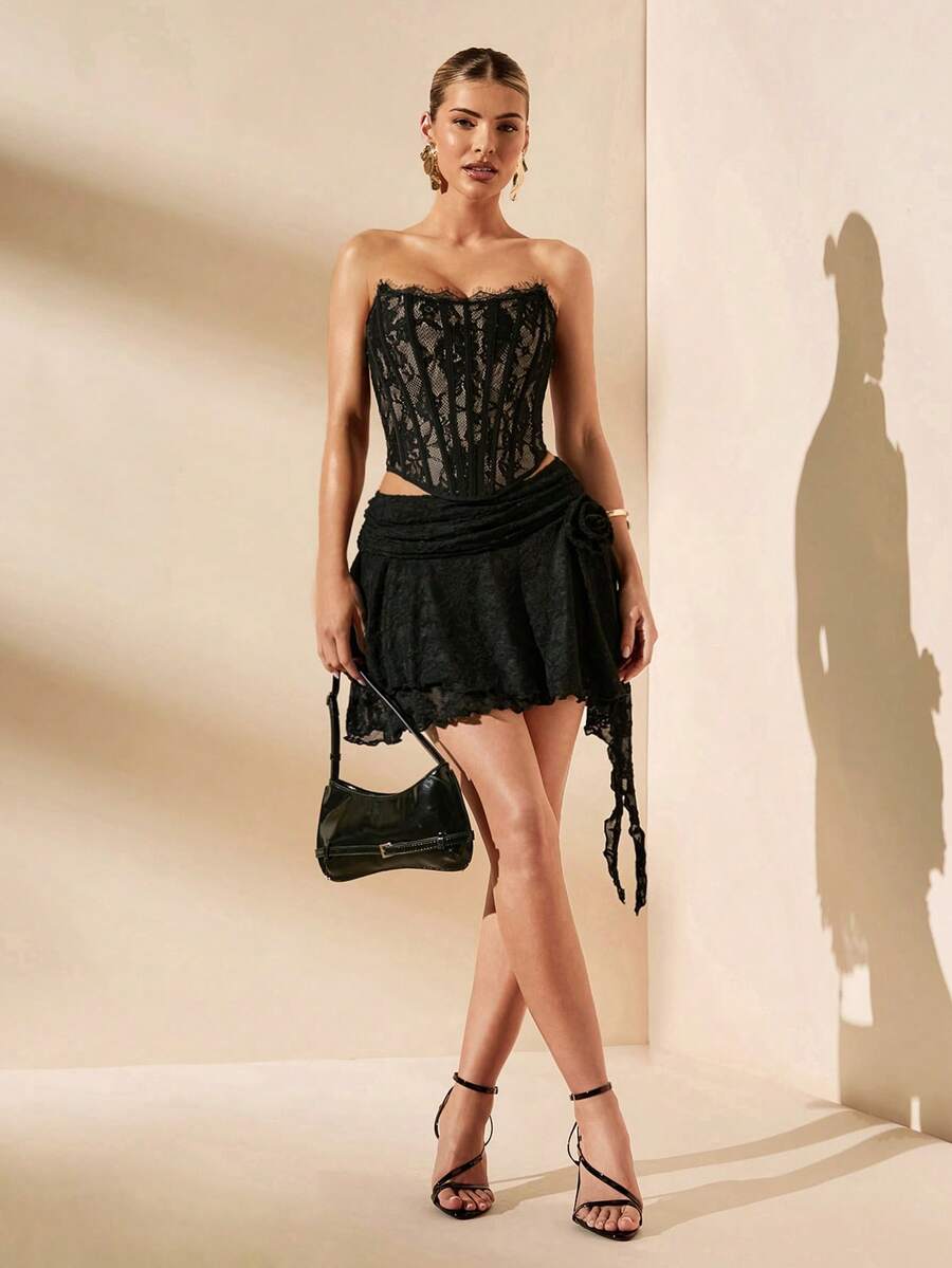 Women's strapless bustier crop top with contrast lace, lace-up detail, and an asymmetric hem in a slim-fit satin finish.