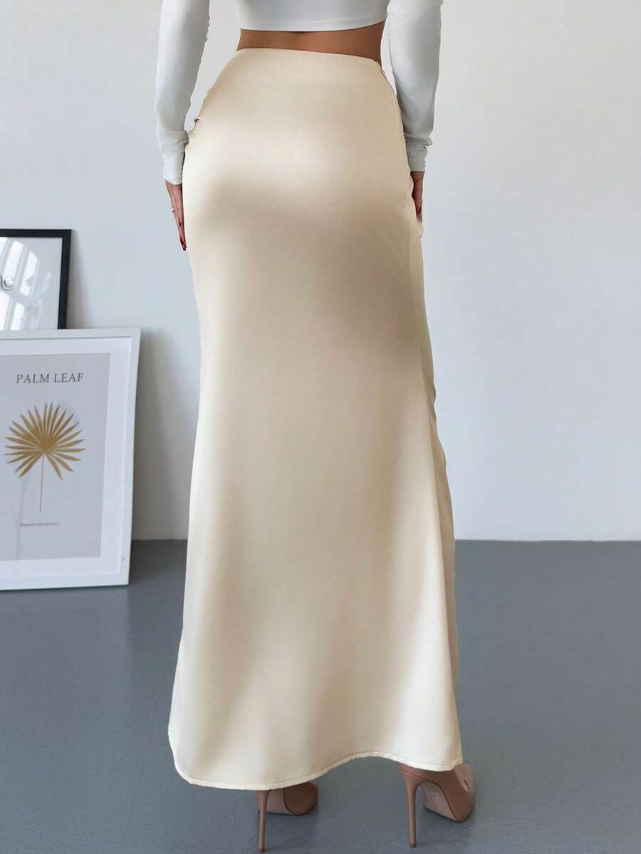 Women's solid color ruched satin maxi skirt featuring an asymmetrical wrap design and side slit.