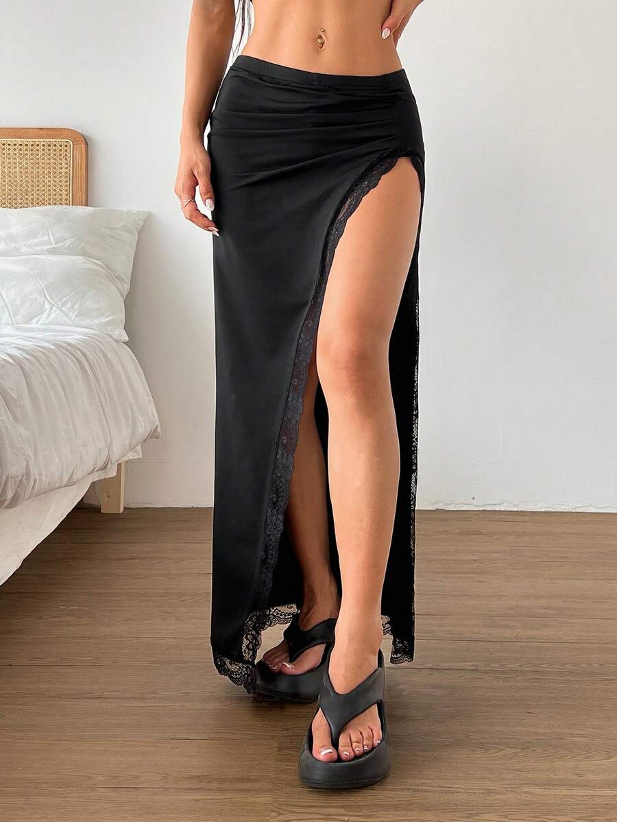 Women's black ruched side slit long bodycon skirt featuring an asymmetrical split thigh design.