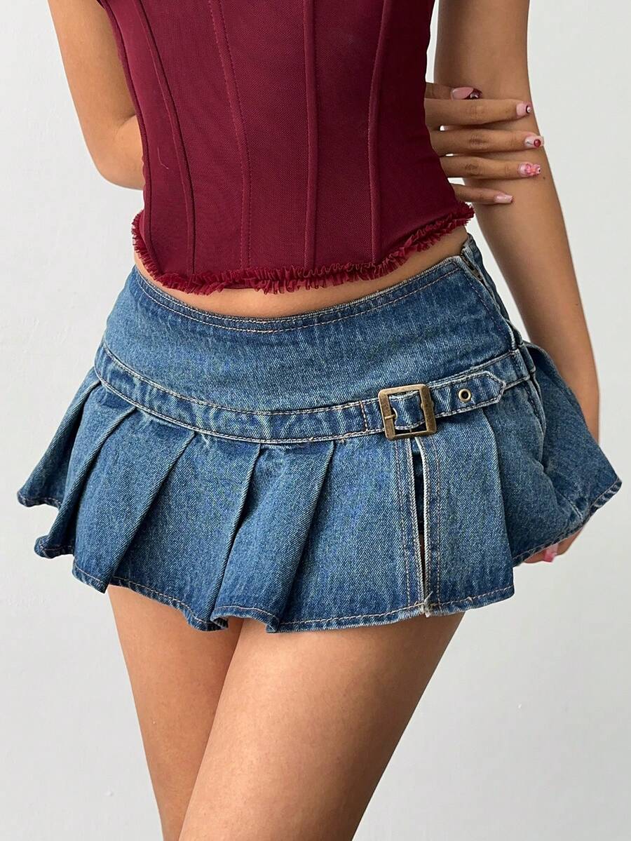 Women's blue denim pleated mini skirt skort featuring a low waist fit with zipper and grommet eyelet details.