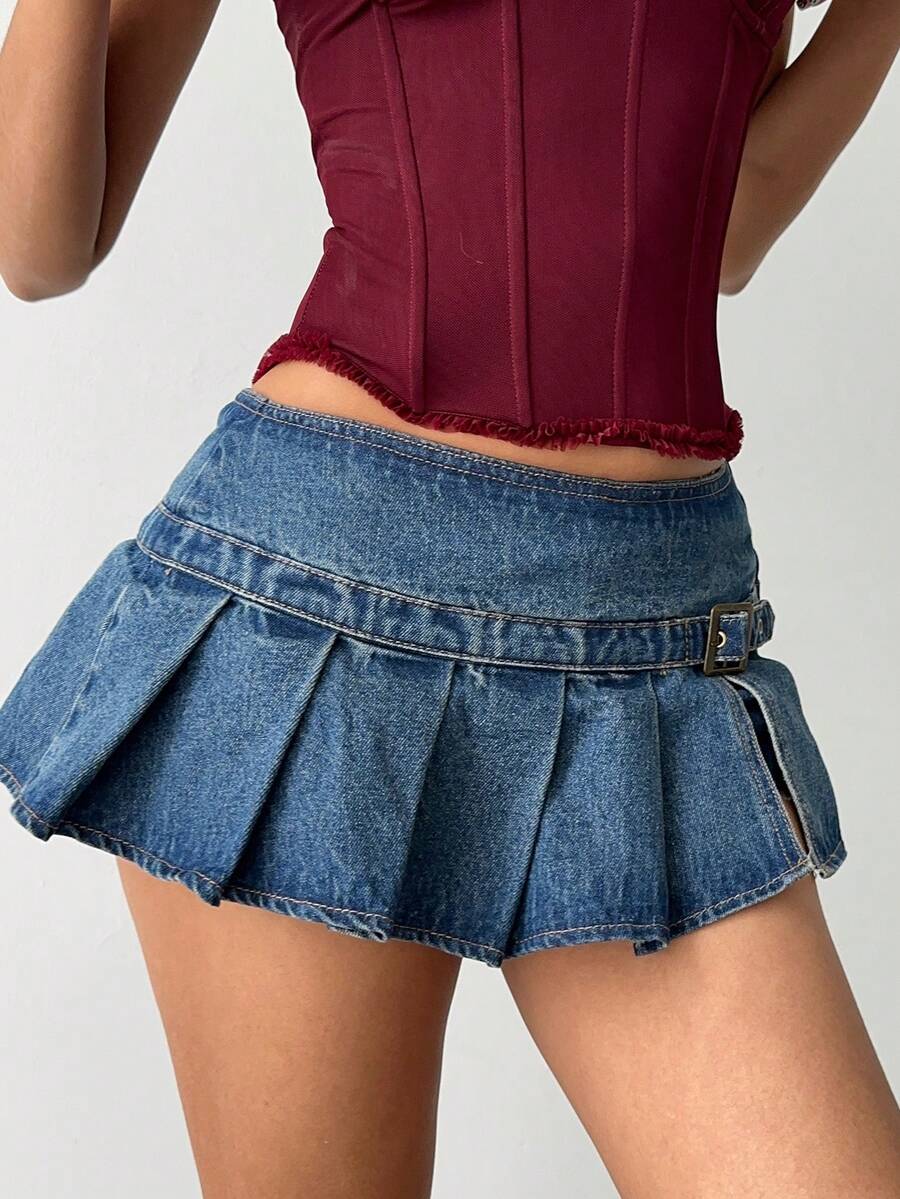Women's blue denim pleated mini skirt skort featuring a low waist fit with zipper and grommet eyelet details.