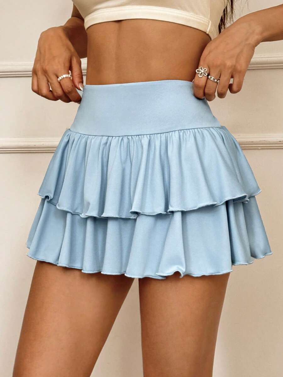 Black low waist knit mini skirt featuring a tiered ruffle hem and skinny high stretch fit.