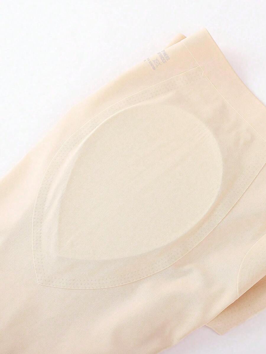 Women's apricot seamless padded shapewear panties featuring tummy control design and teardrop foam padding.