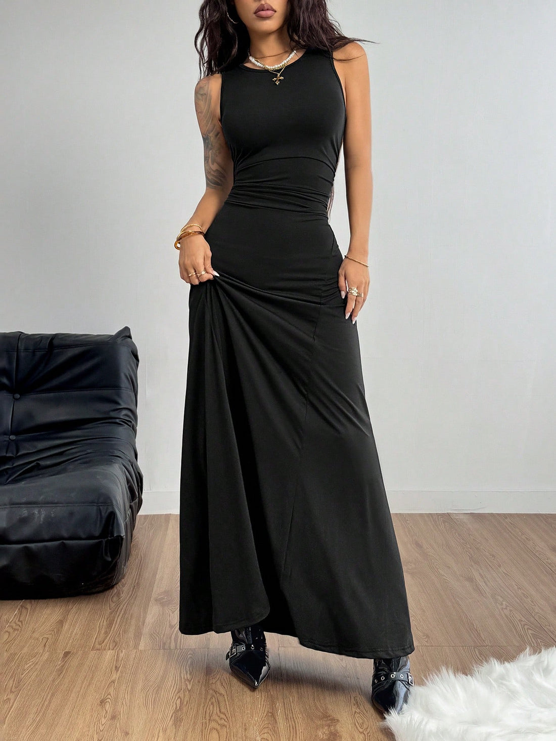 Sleeveless black ruched maxi dress for women featuring a round neck, backless zipper closure, slim fit silhouette, and mermaid hemline.