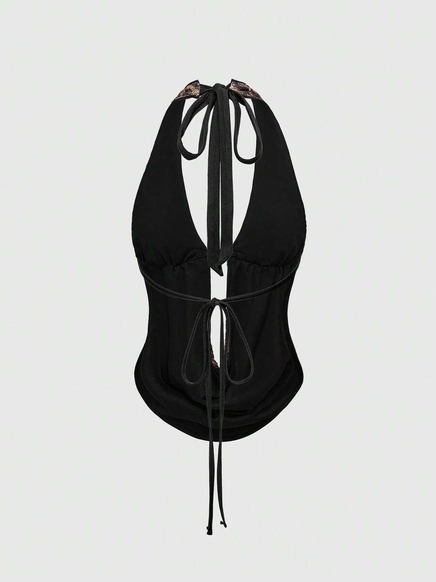 Women's leopard print sequin halter crop top featuring a backless asymmetrical hem design with ring accent.