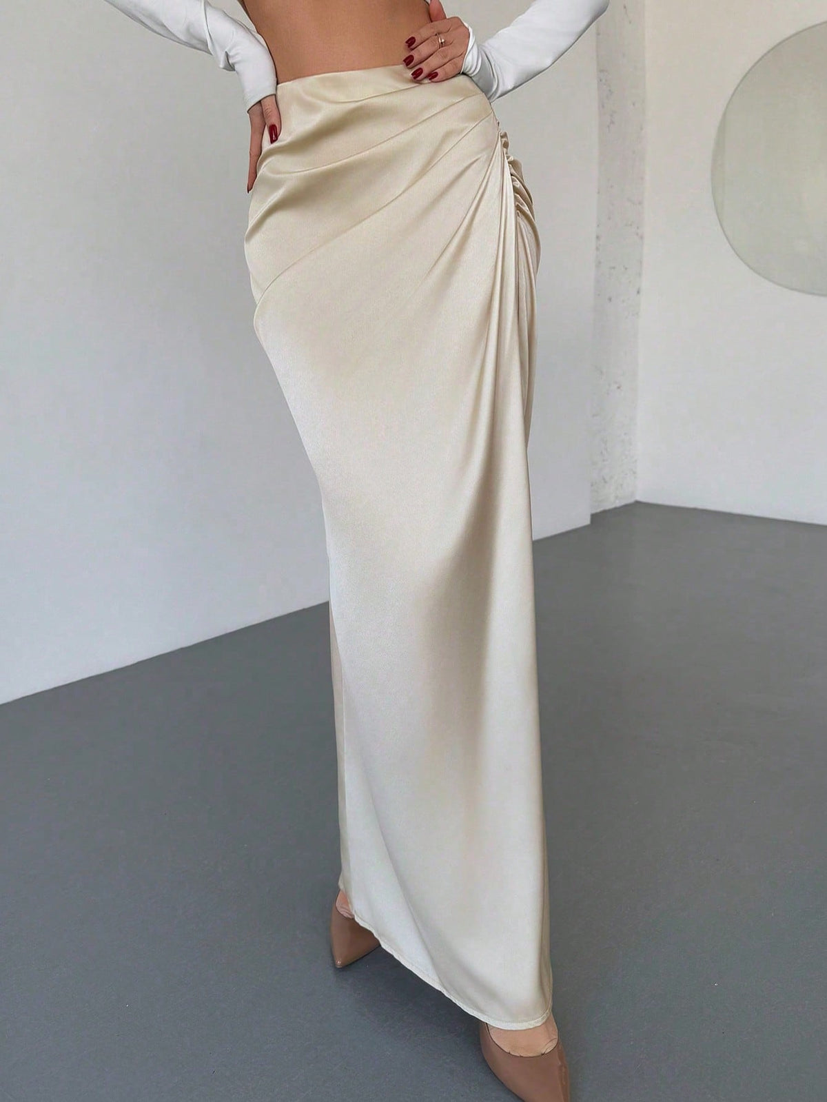 Women's solid color ruched satin maxi skirt featuring an asymmetrical wrap design and side slit.