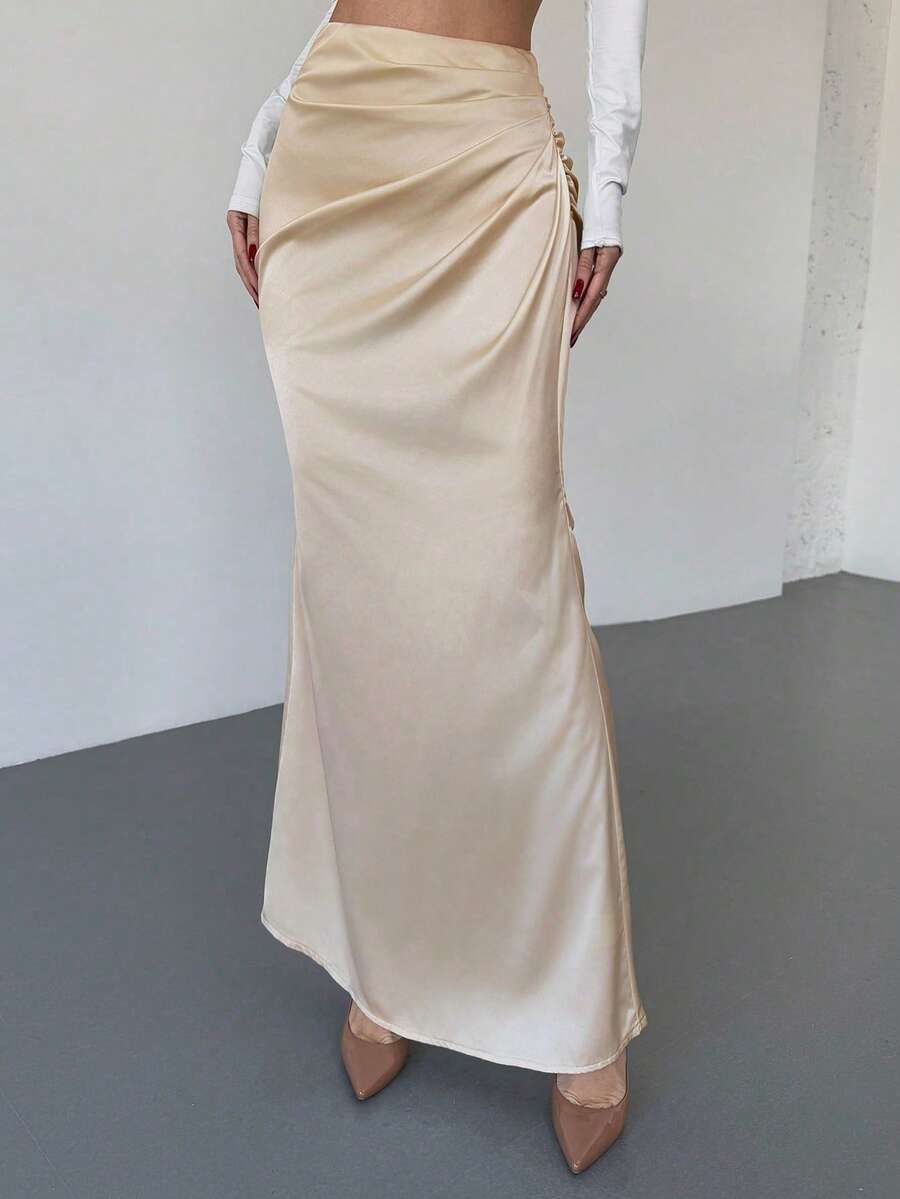 Women's solid color ruched satin maxi skirt featuring an asymmetrical wrap design and side slit.