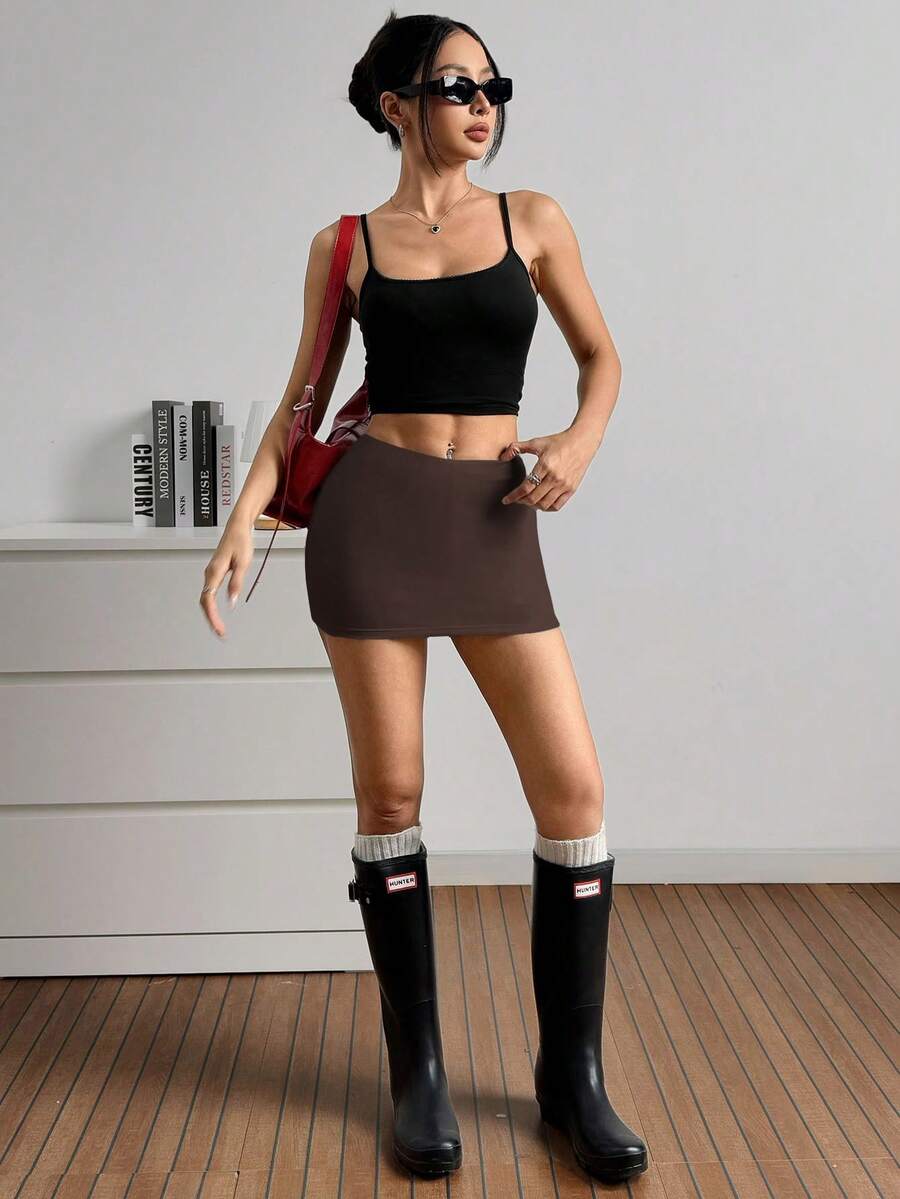 Women's black casual low rise bodycon mini skort with built-in shorts in knitted plain stretch fabric.