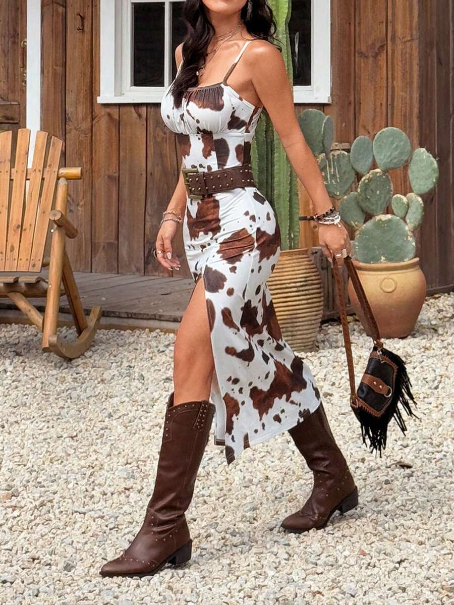 Black and white cow print cami midi dress for women featuring spaghetti straps, ruched bust, backless detail, and a split thigh hem.