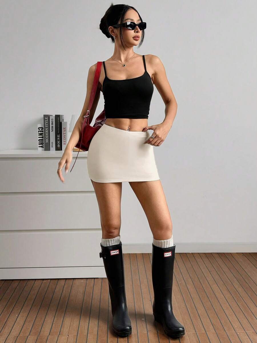 Women's black casual low rise bodycon mini skort with built-in shorts in knitted plain stretch fabric.