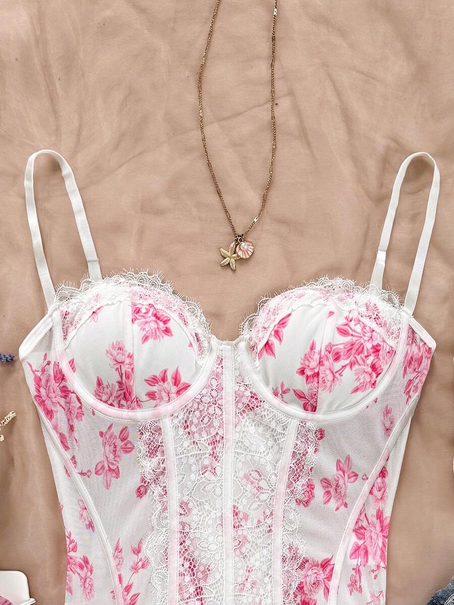 Women's lace bustier camisole top with spaghetti straps, contrast lace, lace-up detail, and an asymmetrical hem in a slim fit design.