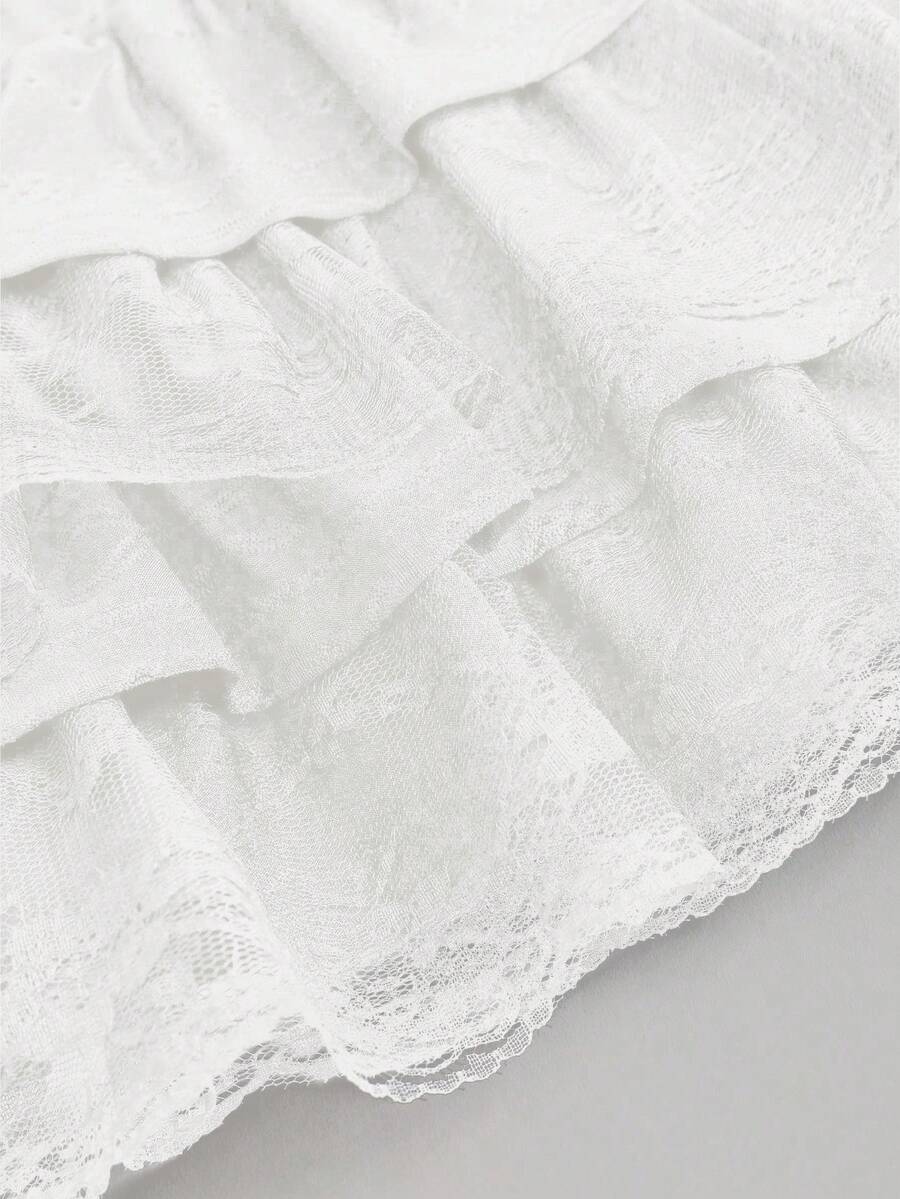 White Y2K layered ruffle mini skirt with contrast lace trim, low waist, and tiered hem.