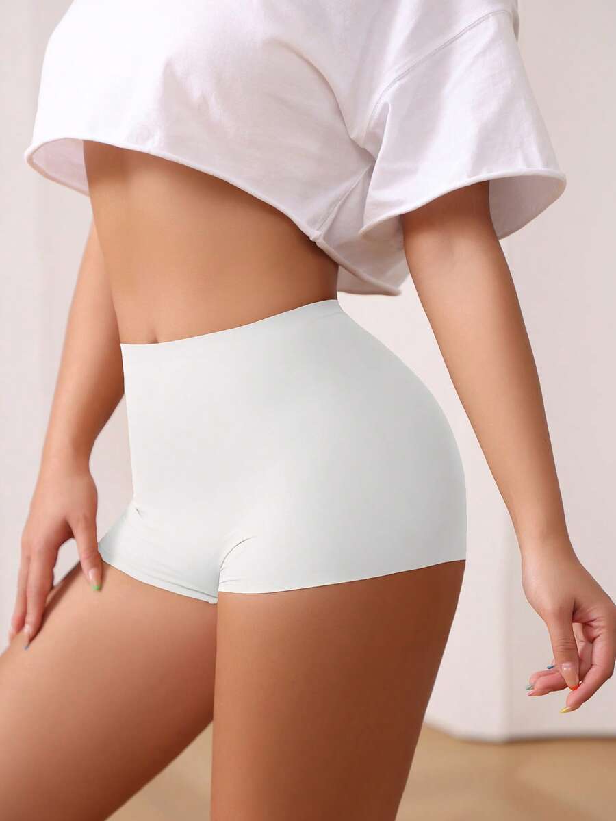 Women's black high stretch shapewear shorts with a mid waist fit and semi-sheer fabric.