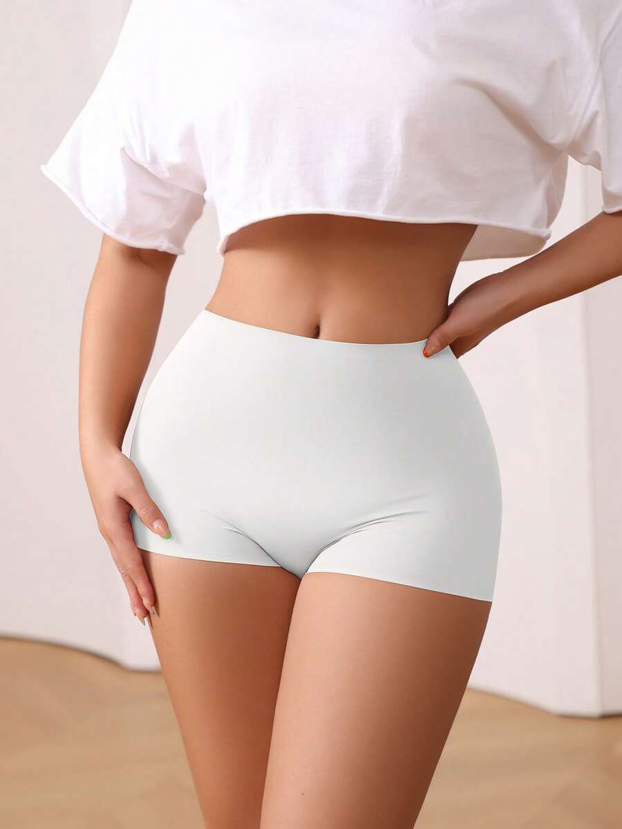 Women's black high stretch shapewear shorts with a mid waist fit and semi-sheer fabric.
