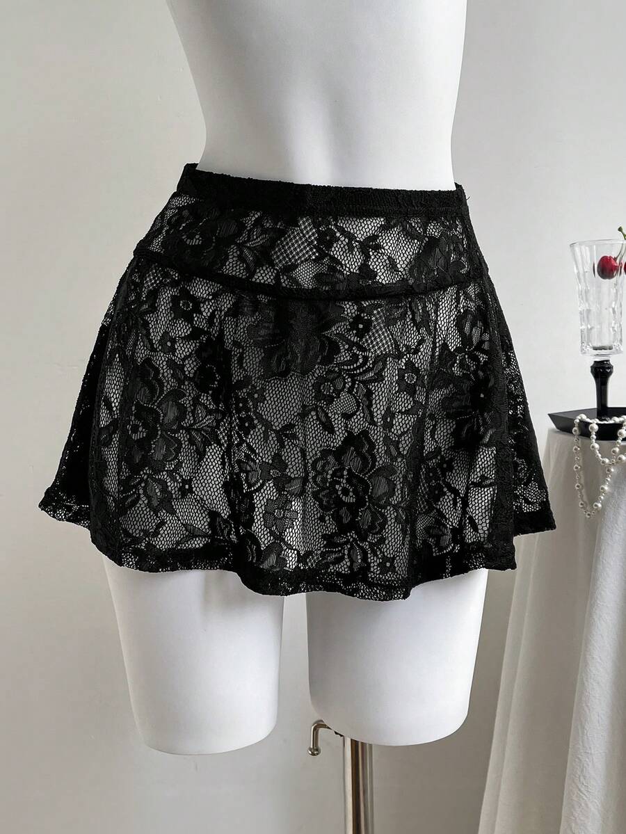 Women's black semi-sheer knitted lace mini skirt featuring a flared ruffle hem and low waist design