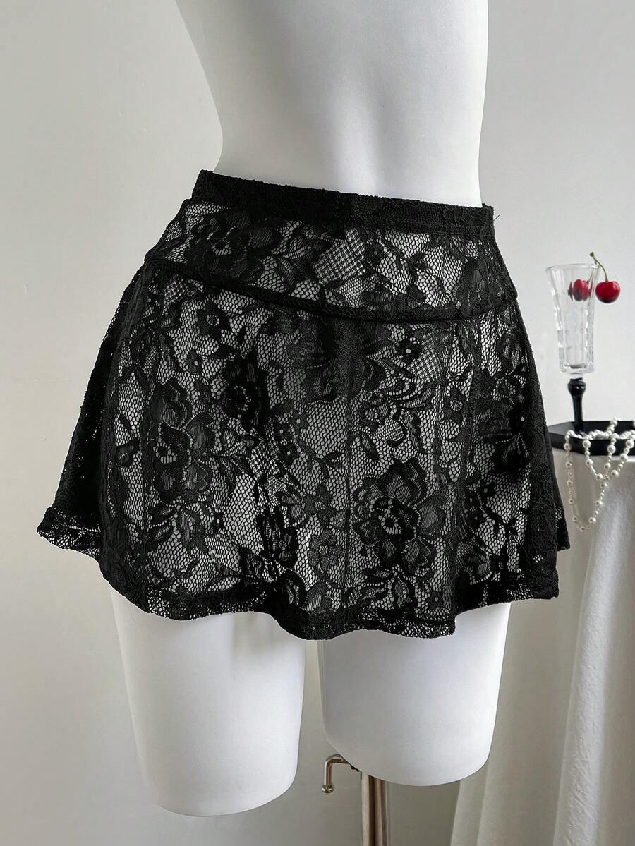Women's black semi-sheer knitted lace mini skirt featuring a flared ruffle hem and low waist design