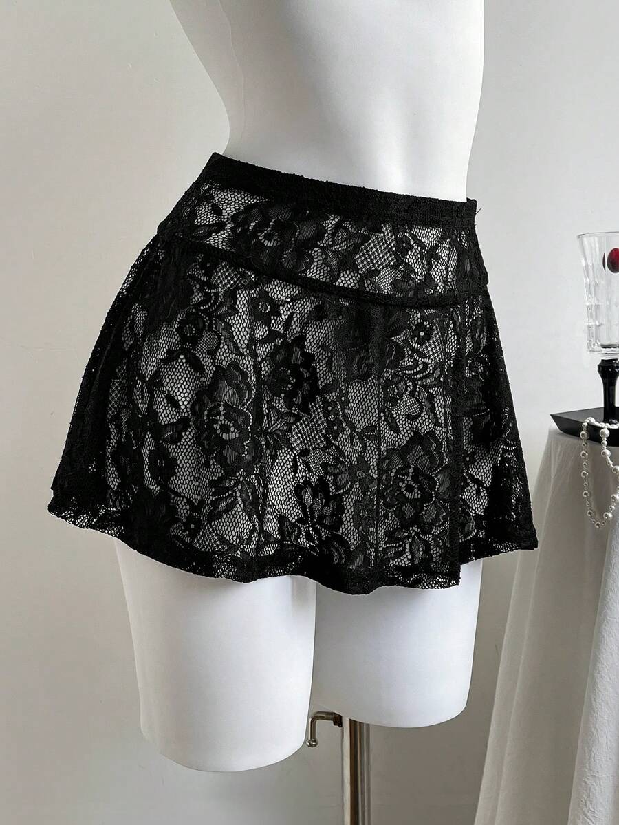 Women's black semi-sheer knitted lace mini skirt featuring a flared ruffle hem and low waist design