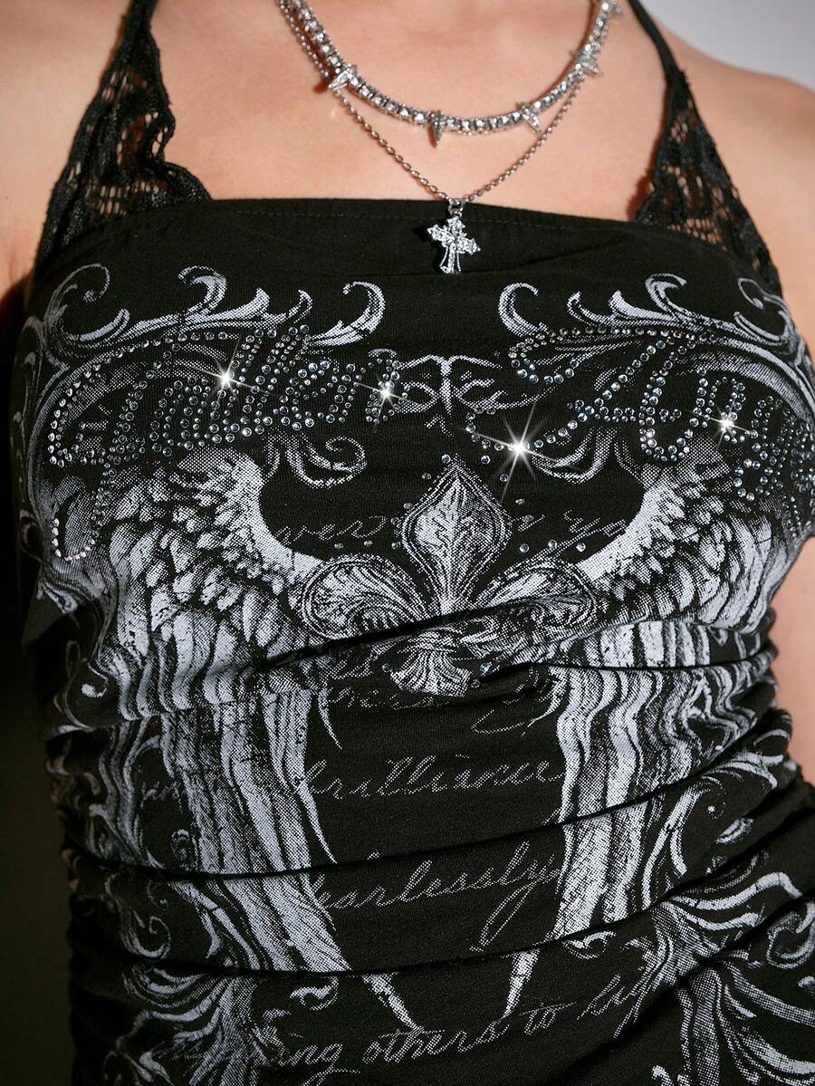 Woman wearing a black Y2K concert print 2-in-1 contrast lace halter crop top featuring a backless design with knot details.