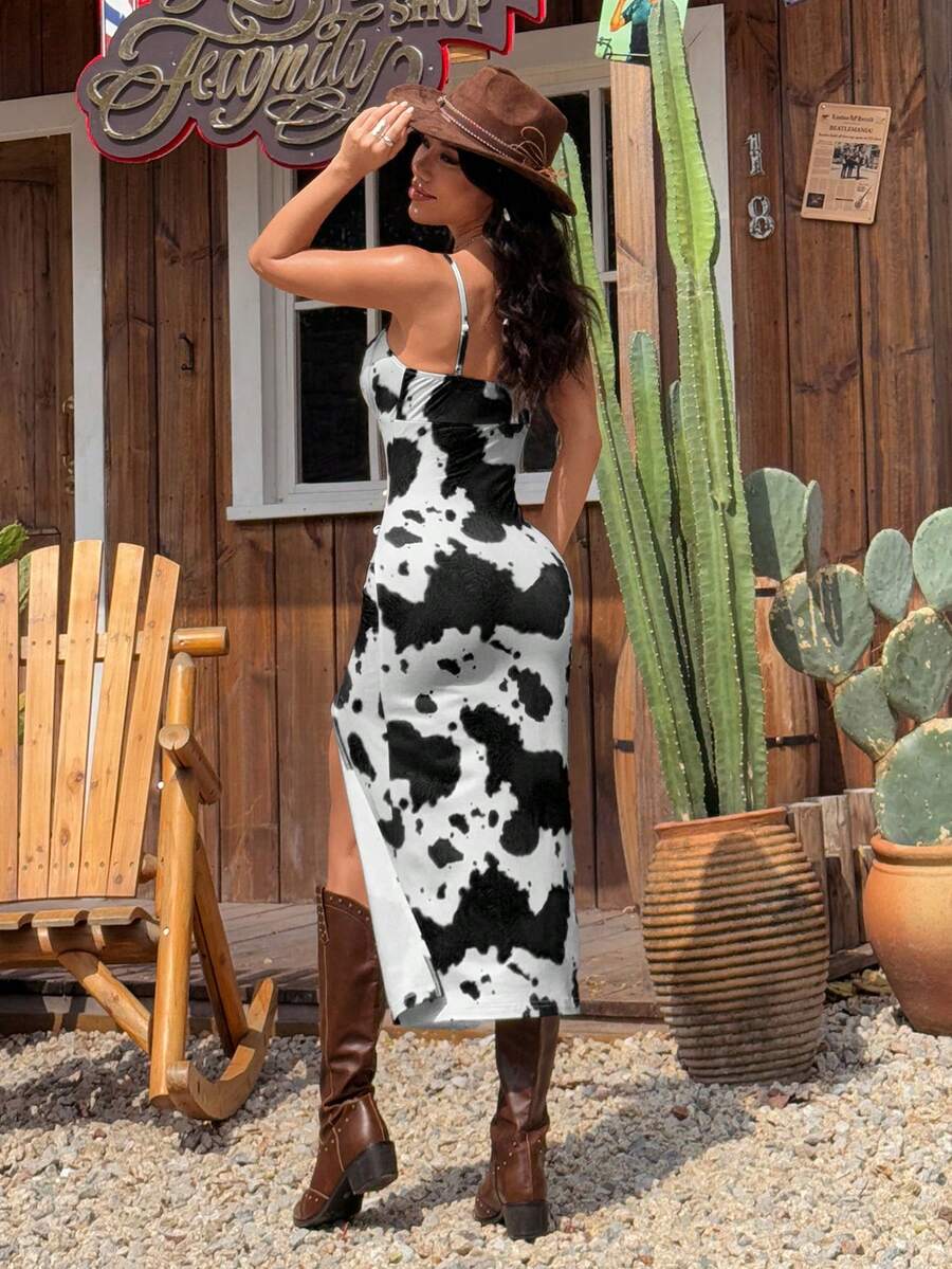 Black and white cow print cami midi dress for women featuring spaghetti straps, ruched bust, backless detail, and a split thigh hem.