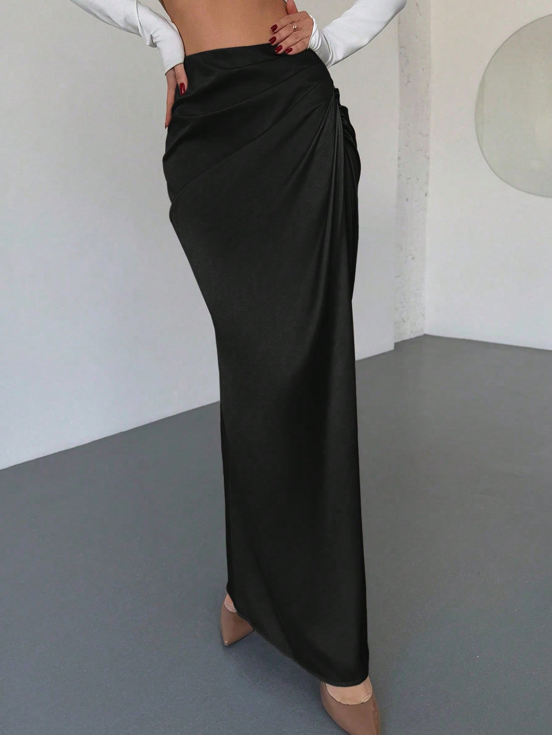 Women's solid color ruched satin maxi skirt featuring an asymmetrical wrap design and side slit.