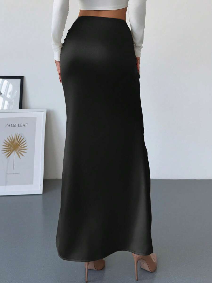 Women's solid color ruched satin maxi skirt featuring an asymmetrical wrap design and side slit.