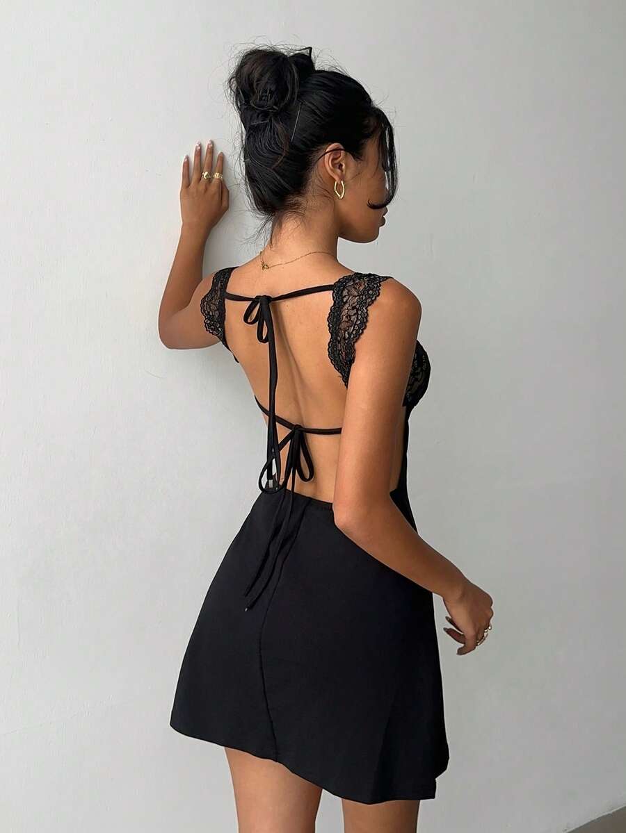 A woman wearing a sleeveless black lace patchwork bodycon mini dress with a stand collar and backless design for a night out.