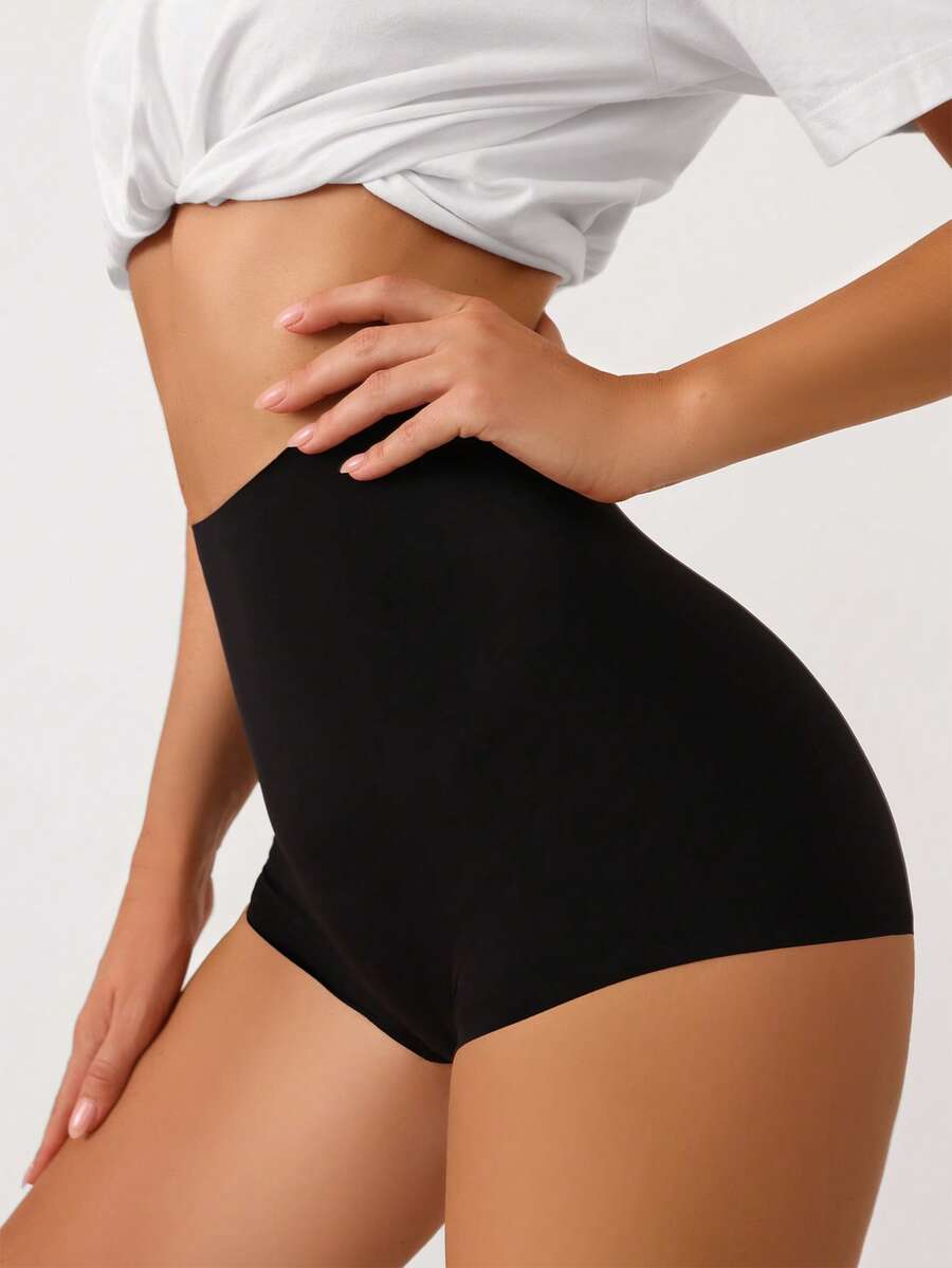 Women's black high stretch shapewear shorts with a mid waist fit and semi-sheer fabric.