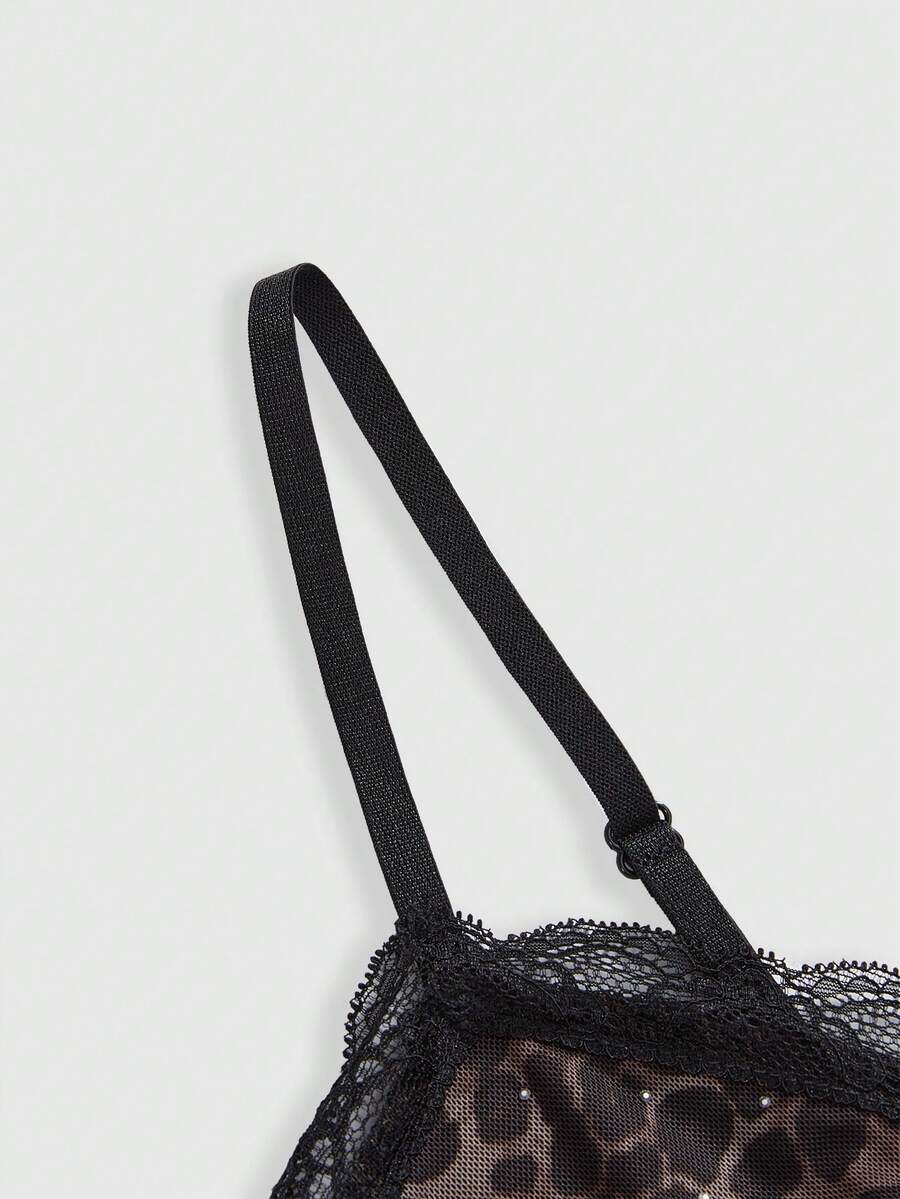 A slim-fit black crop camisole top for women featuring contrast lace trim, leopard print patchwork, rhinestone embellishments, spaghetti straps, an asymmetrical hem, and matching arm sleeves.