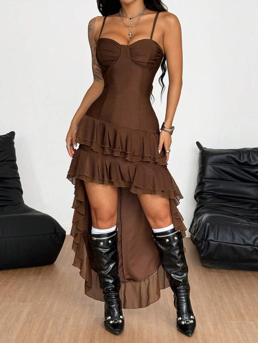 Front view of a woman wearing a sleeveless black slim fit cami maxi dress with spaghetti straps and an asymmetrical tiered ruffle hem.