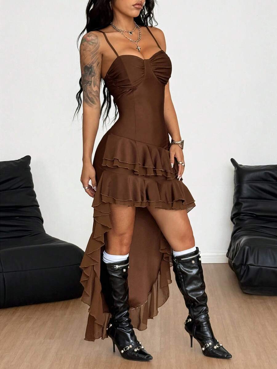 Front view of a woman wearing a sleeveless black slim fit cami maxi dress with spaghetti straps and an asymmetrical tiered ruffle hem.
