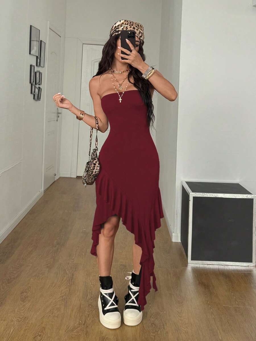 Women's strapless black bandeau midi dress featuring an asymmetrical ruffle hem and a slim fit bodycon silhouette.
