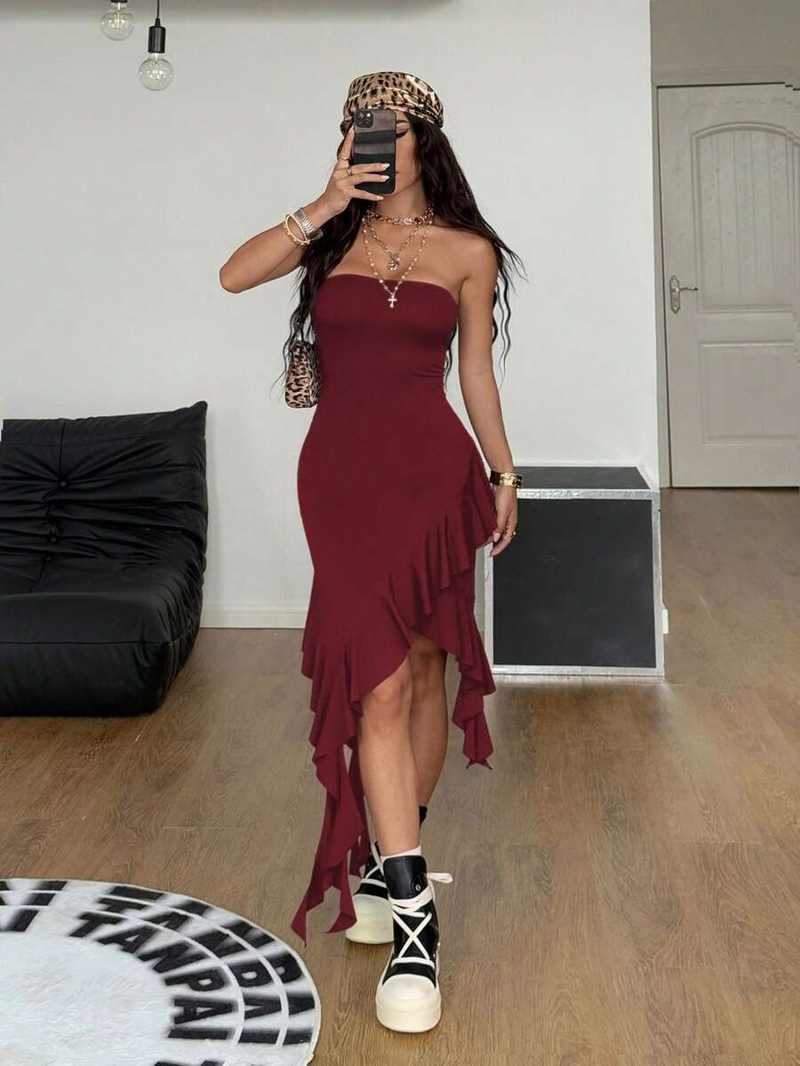 Women's strapless black bandeau midi dress featuring an asymmetrical ruffle hem and a slim fit bodycon silhouette.