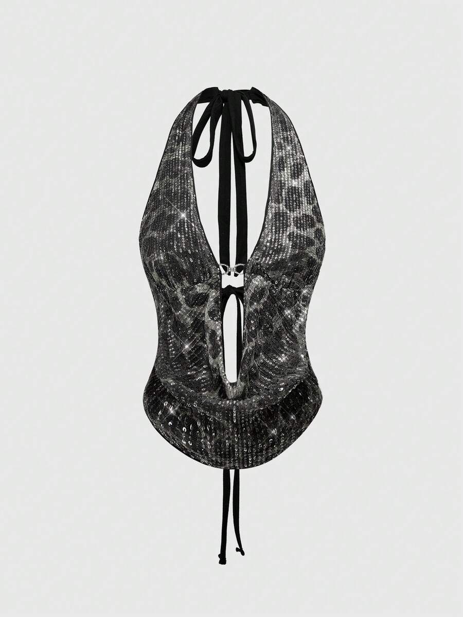 Women's leopard print sequin halter crop top featuring a backless asymmetrical hem design with ring accent.