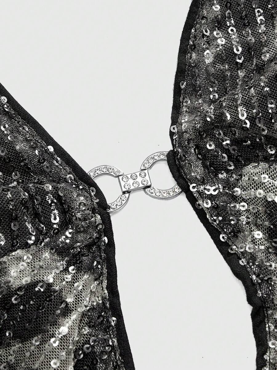 Women's leopard print sequin halter crop top featuring a backless asymmetrical hem design with ring accent.