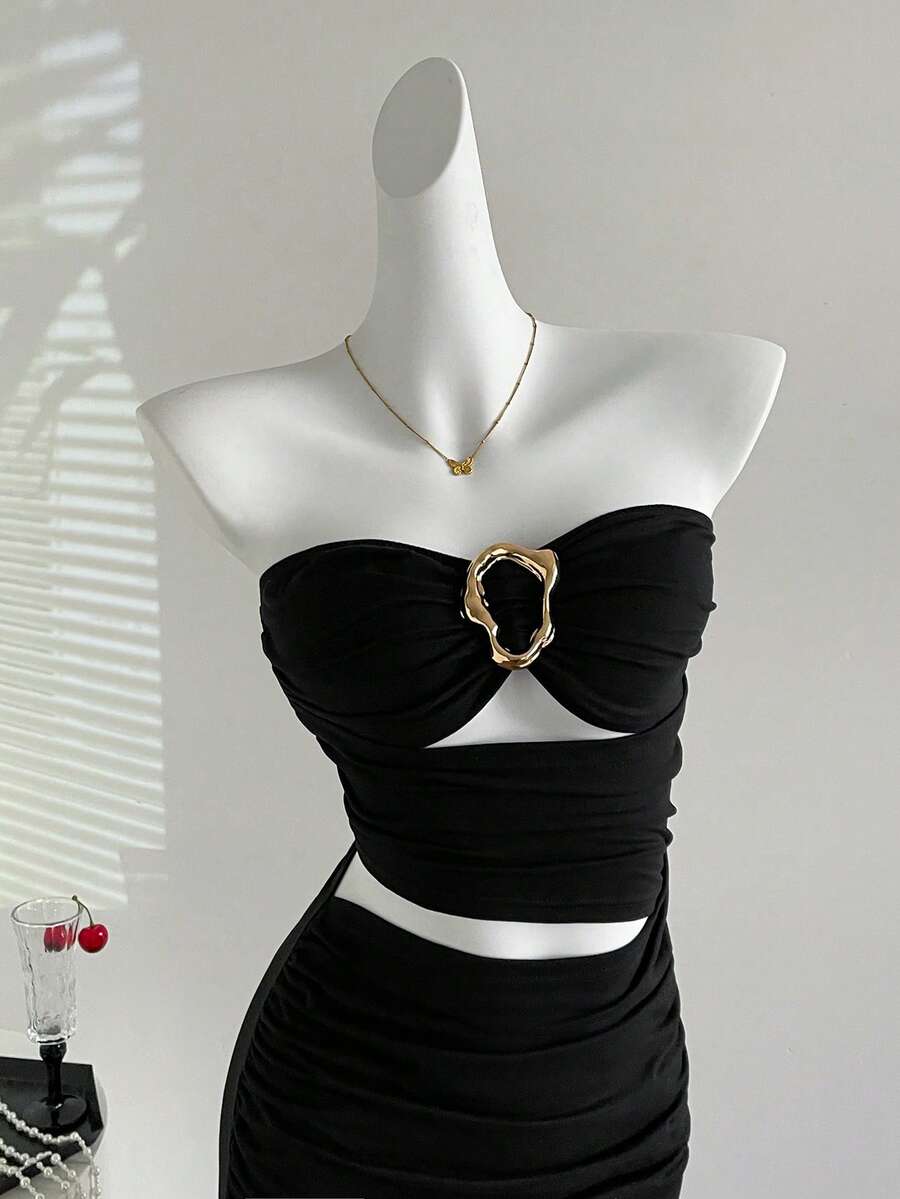 Women's black strapless bodycon mini dress featuring ruched detailing, cut-out design with ring accent, mid-waist pencil hem, and slim fit knitted stretch fabric.