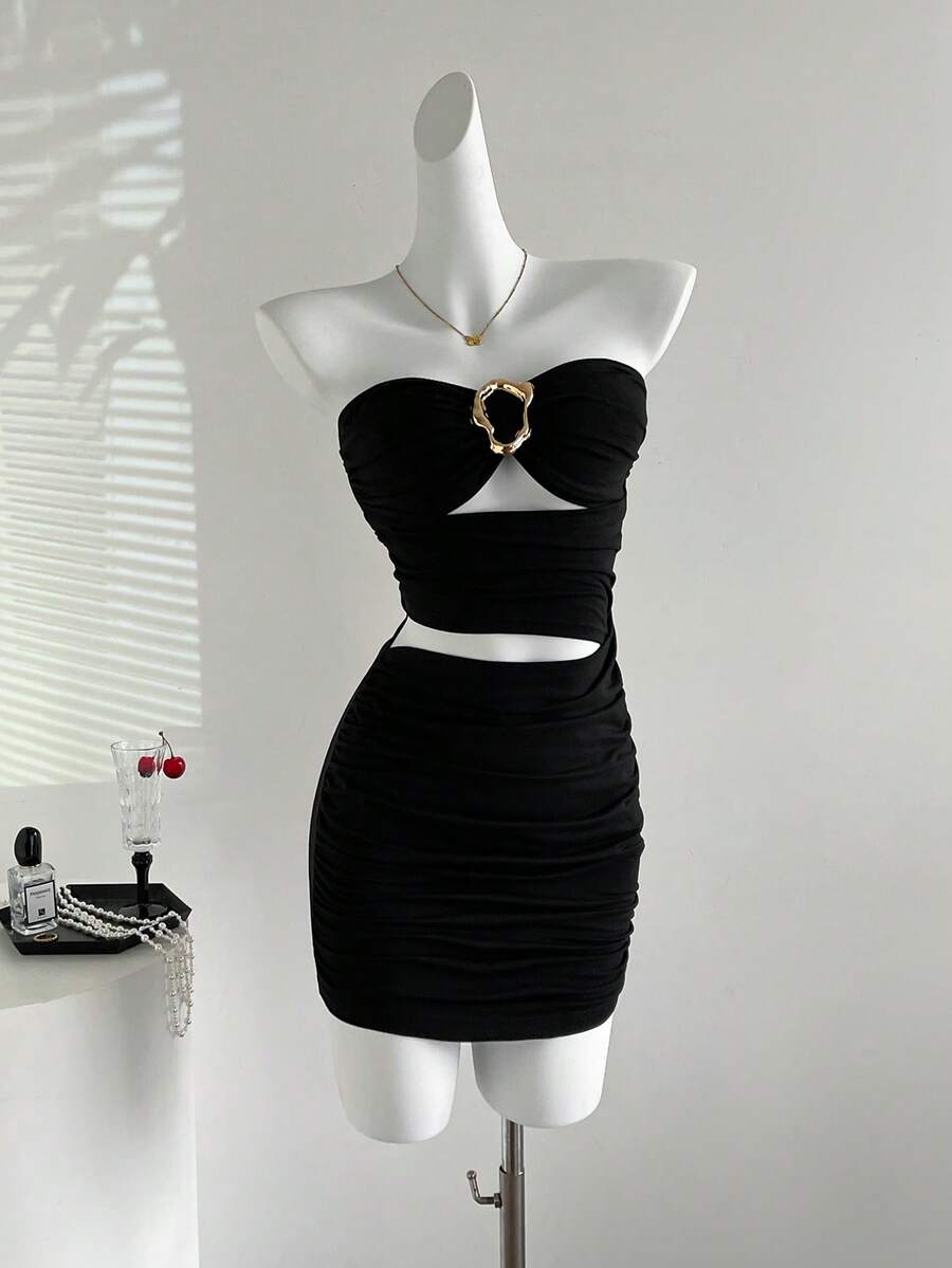 Women's black strapless bodycon mini dress featuring ruched detailing, cut-out design with ring accent, mid-waist pencil hem, and slim fit knitted stretch fabric.