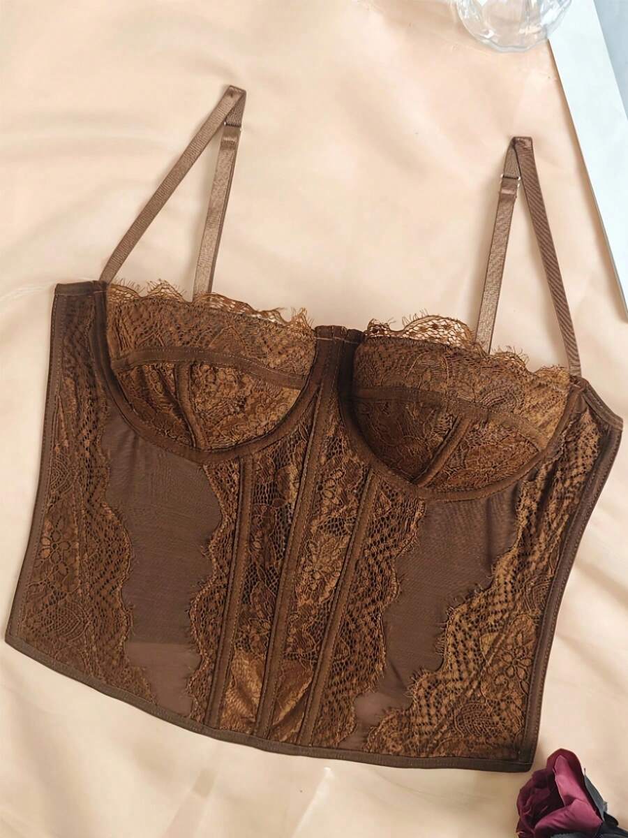 Black lace bustier corset top for women with buckle detail, spaghetti straps, slim fit, and lightweight mesh fabric for a night out look.