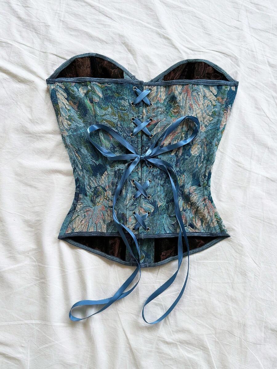 Strapless black lace-up corset top for women with grommet eyelet details, slim fit, lined body, and woven fabric construction.