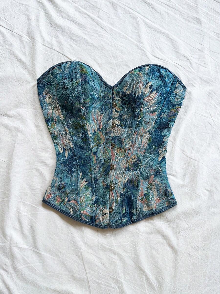 Strapless black lace-up corset top for women with grommet eyelet details, slim fit, lined body, and woven fabric construction.