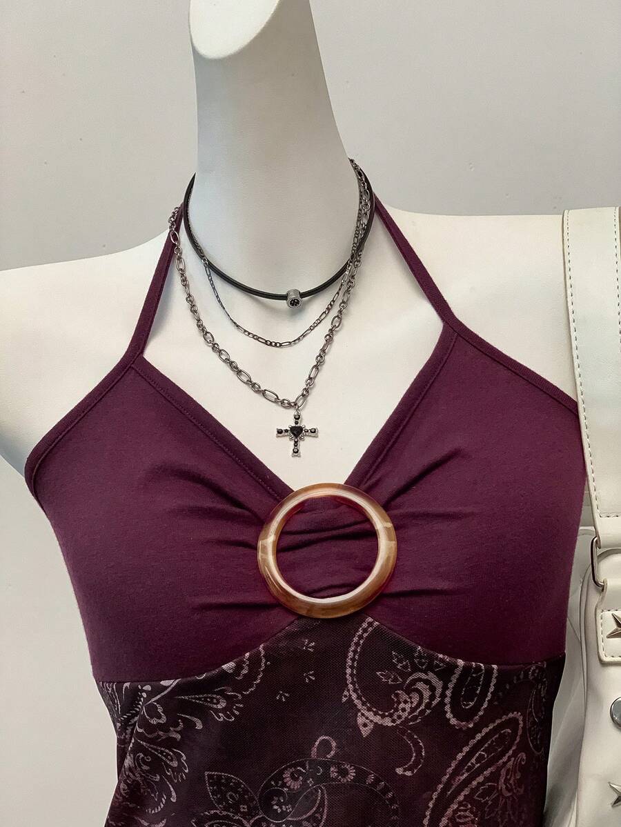 Women's backless halter cami top featuring a paisley print, sleeveless design, and an asymmetrical hem in knitted fabric.