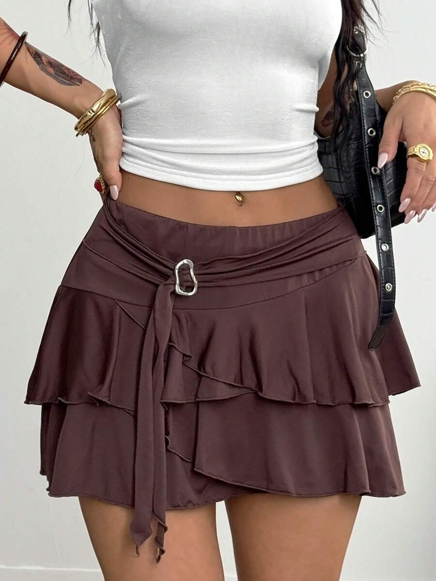 Black low waist tiered mini skirt featuring a ruffle hem and ring accent detail on knitted stretch fabric for women.
