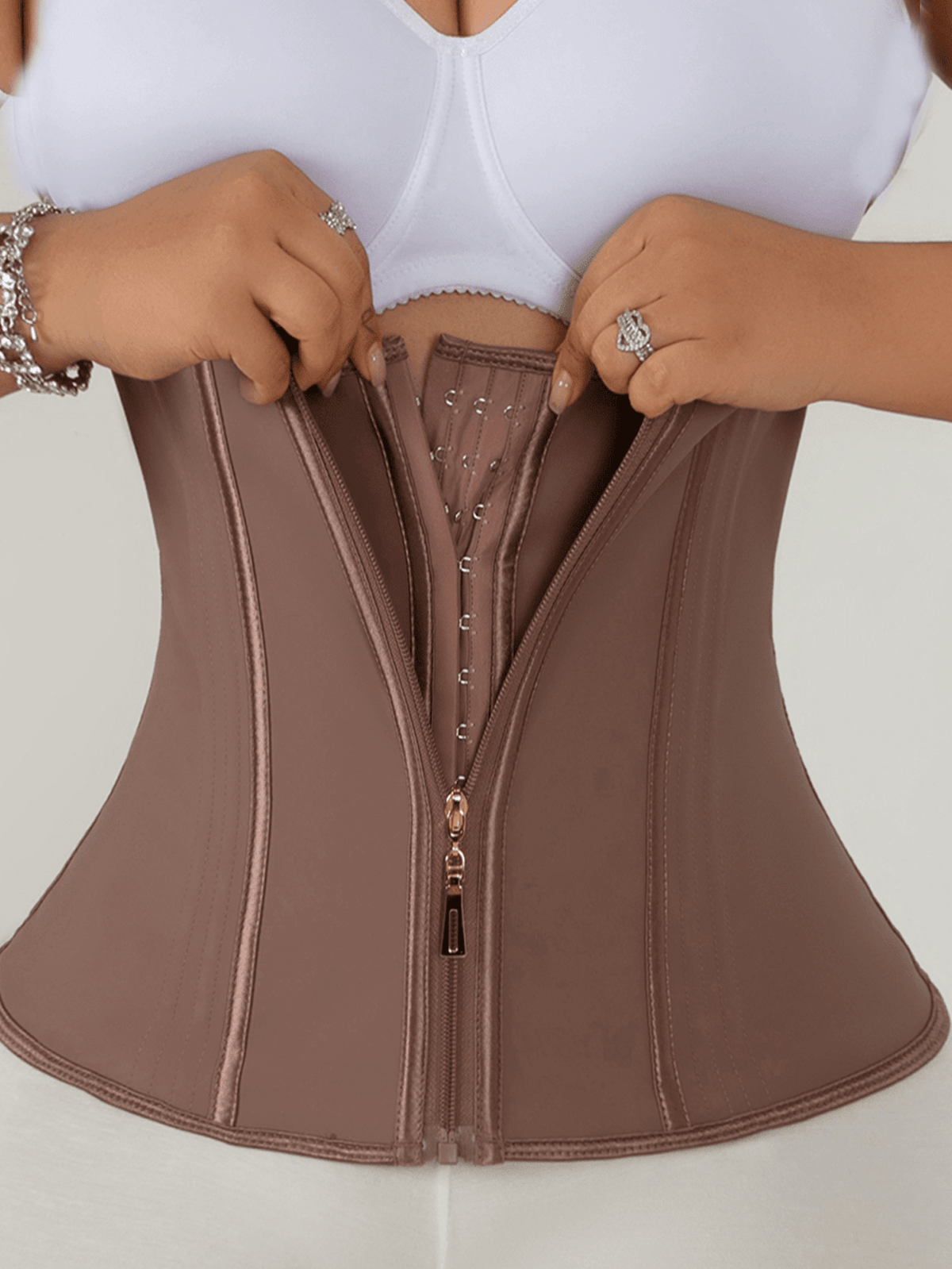 Women's latex waist trainer body shaper featuring zipper front closure and strong tummy support.