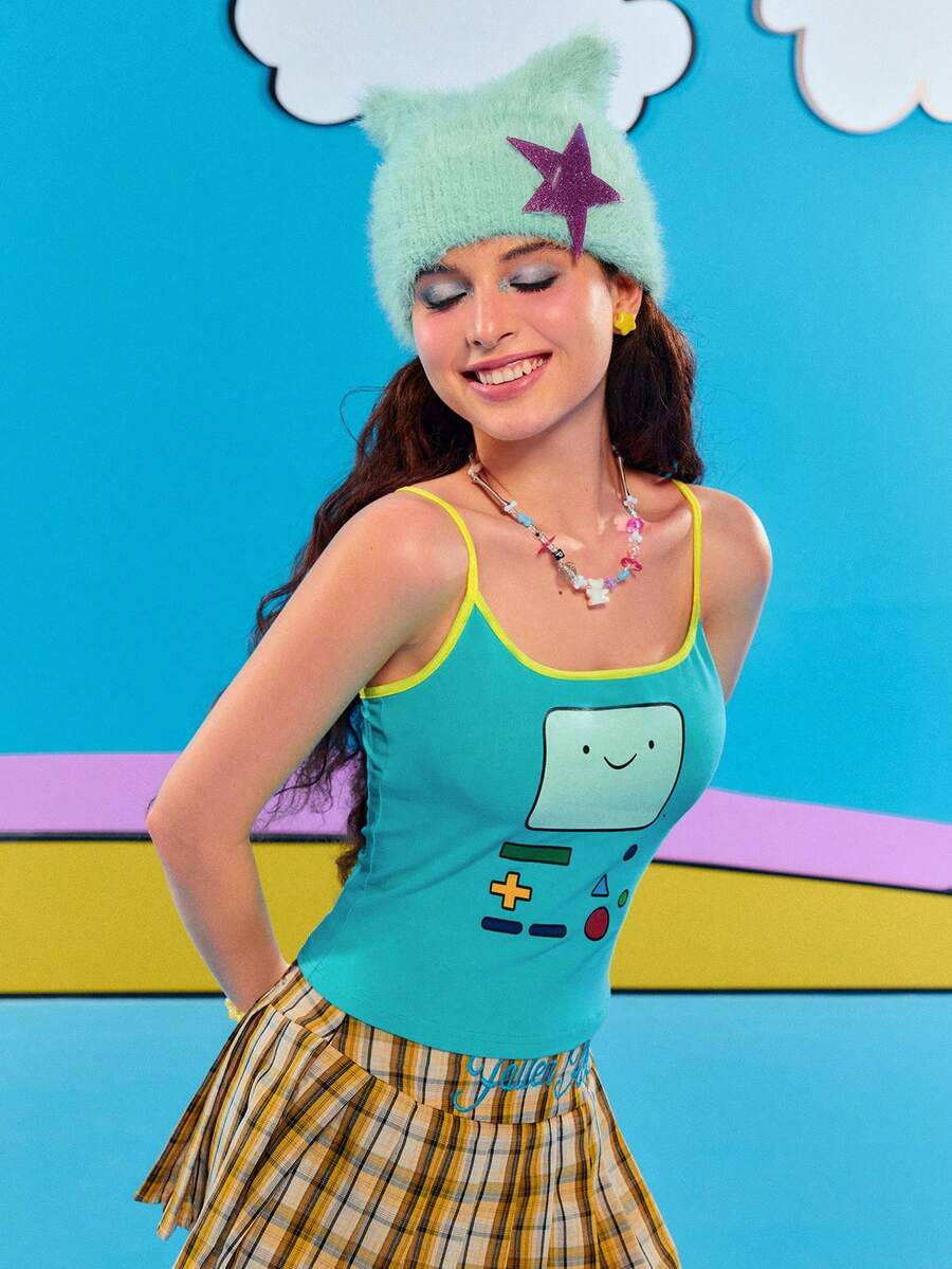 Teal blue slim fit crop camisole top for women featuring a graphic cartoon face print, contrast color trim, and thin spaghetti straps.